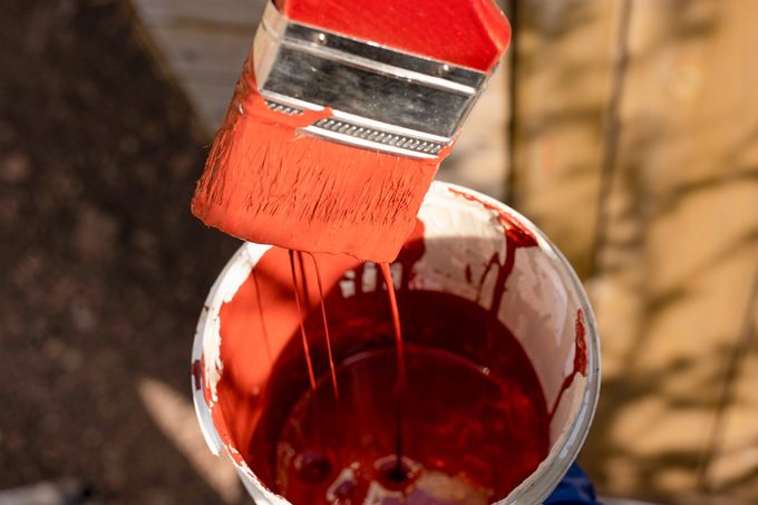 wet paint flowing from brush into bucket