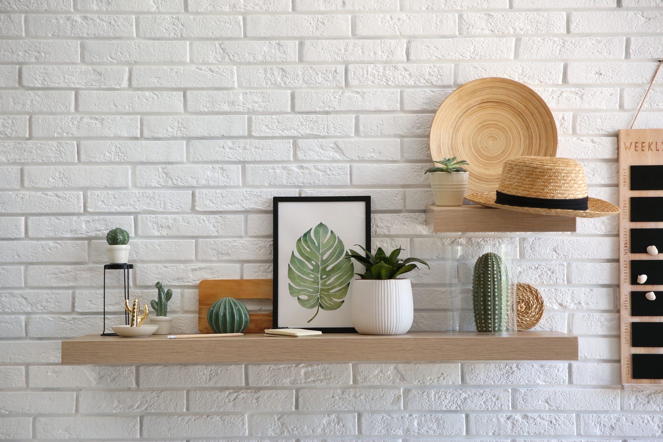 Shelves with decorative elements on white brick wall