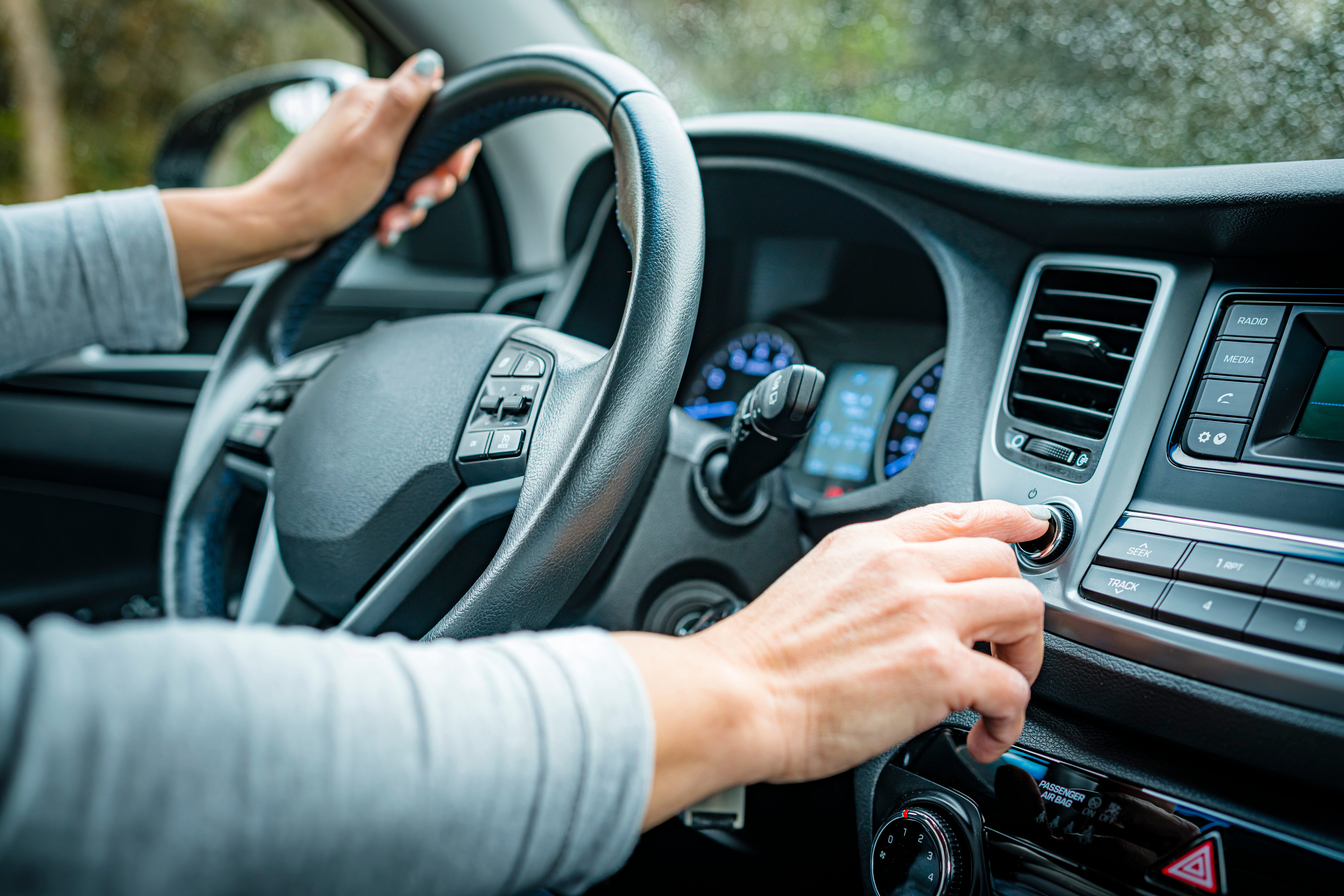 Adjusting Car Stereo Button While Driving In A Rainy Day