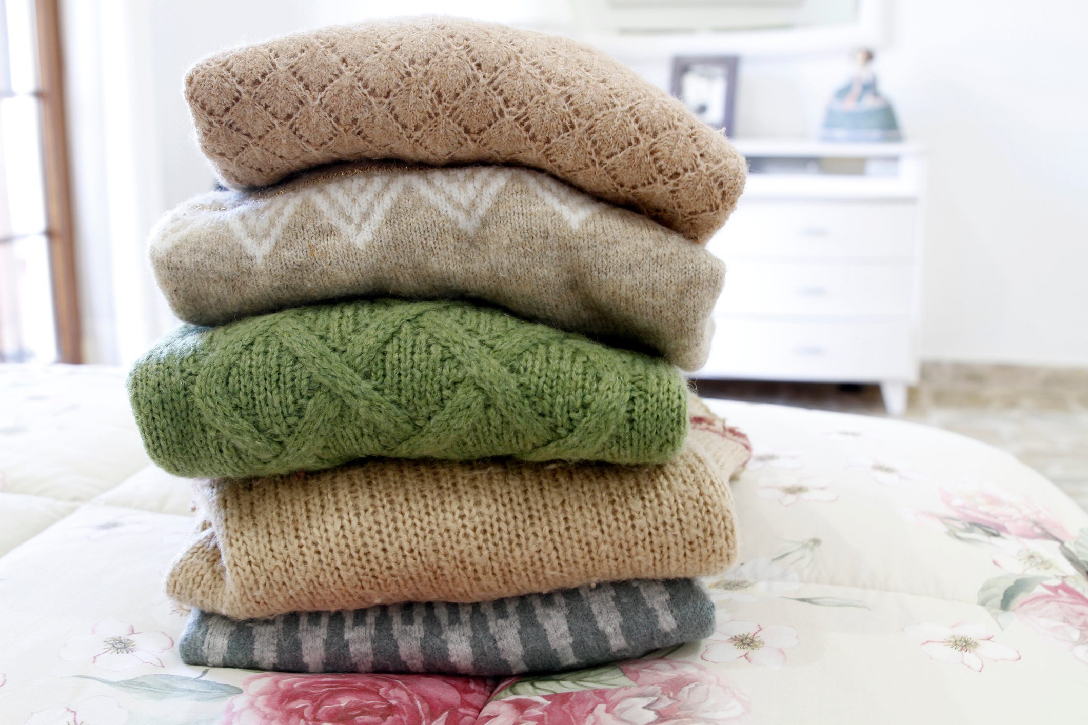 Stack Of Woolen Sweaters on bed