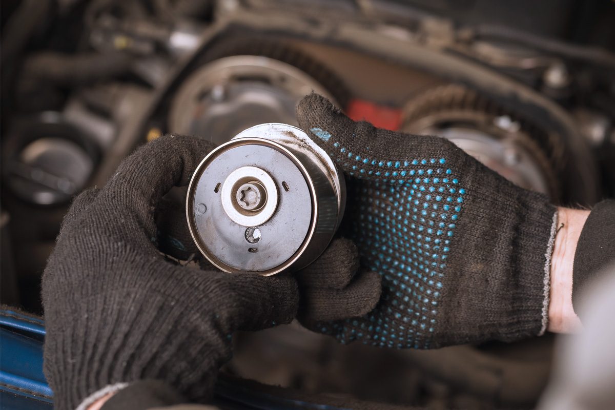 mechanic inspecting timing belt tensioner