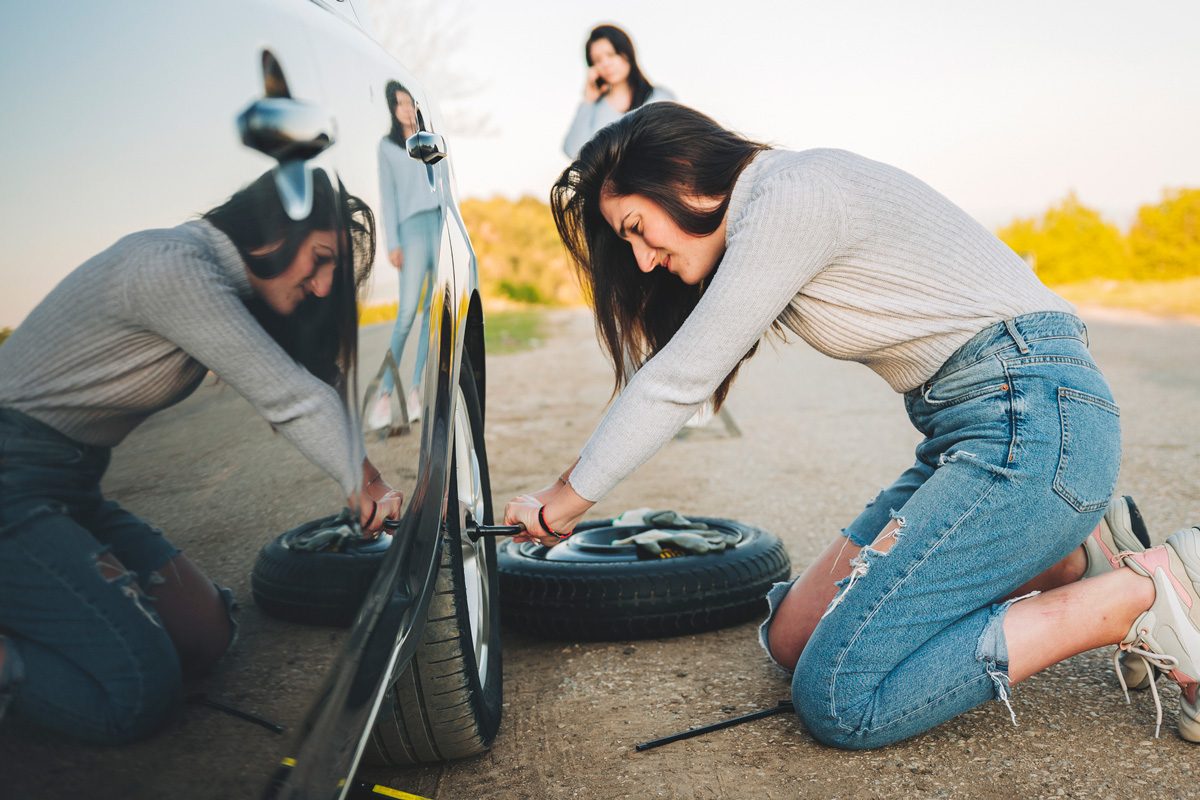 woman changing flat tire