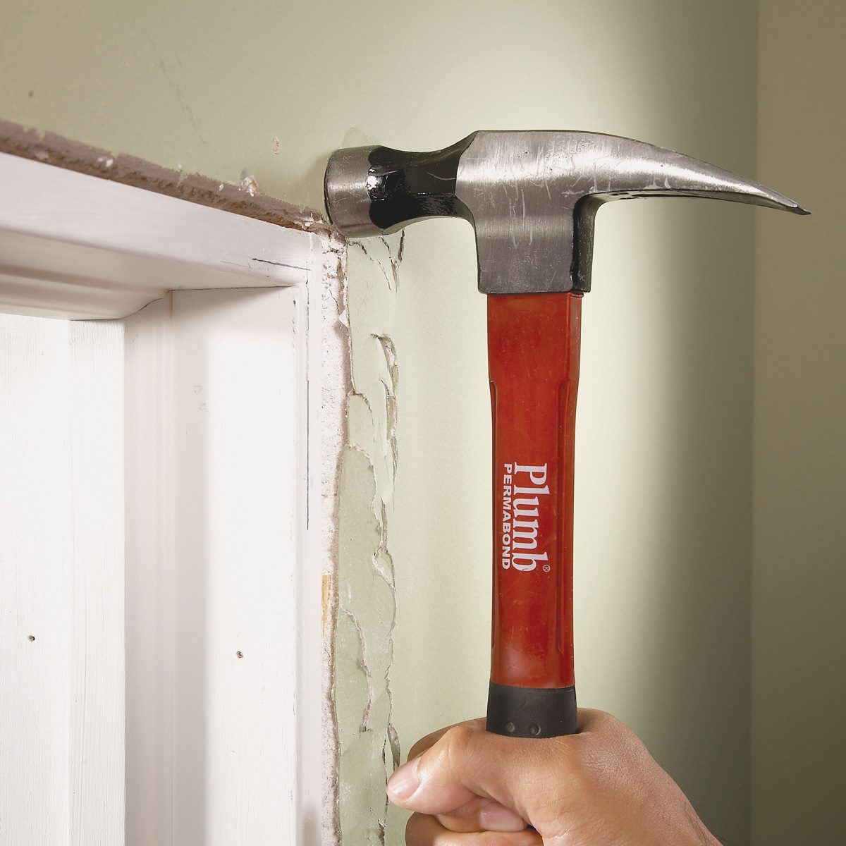 smashing protruding drywall with hammer